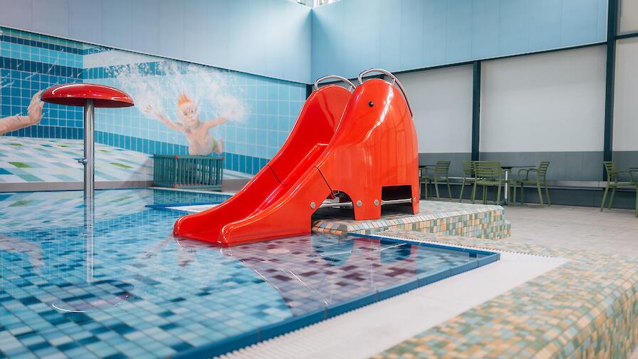 Planschbecken mit einer roten Rutsche in Elefantenform.