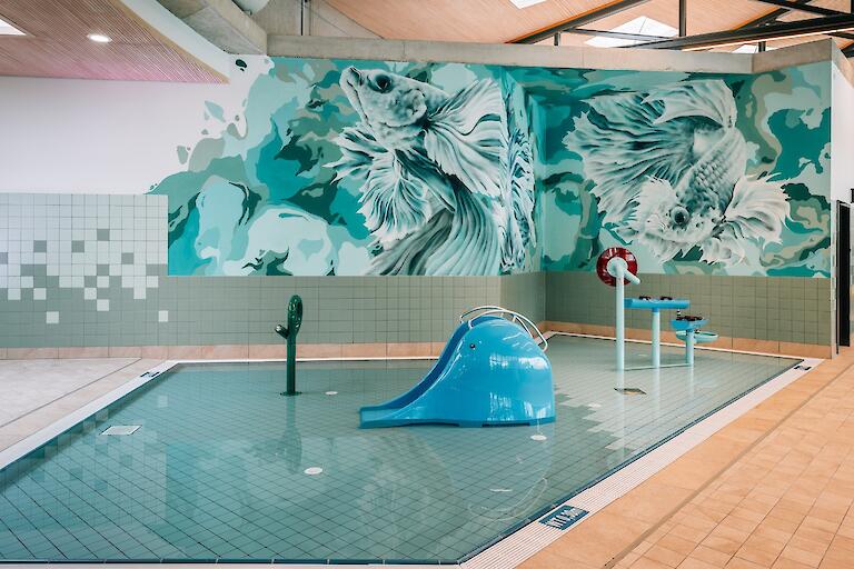 Kleinkinderbecken mit kleiner Rutsche und weiteren Attraktionen für Kinder.