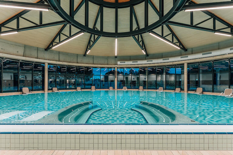 Vitalwarmwasserbecken mit Liegen am Beckenrand.